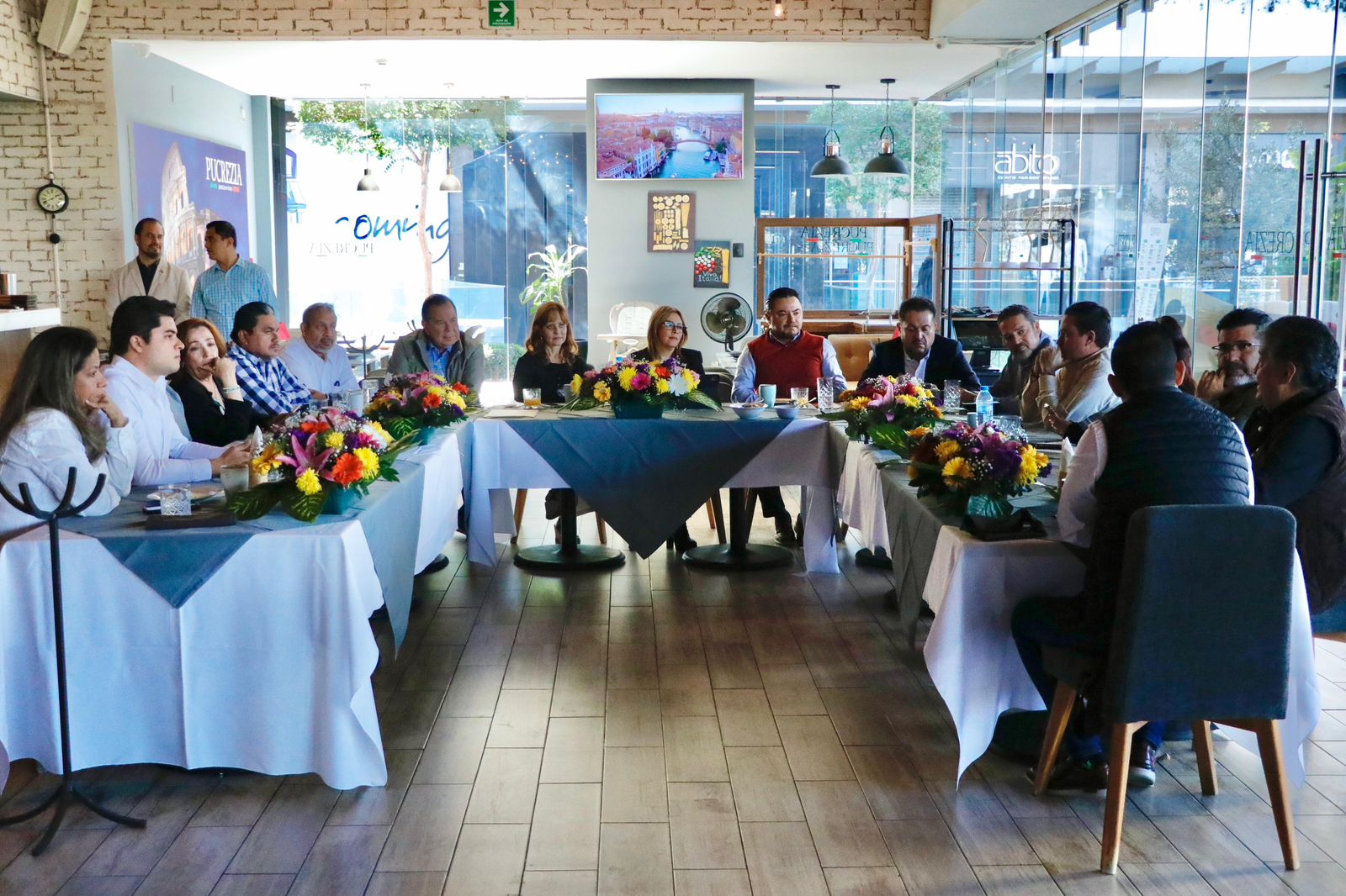 Un grupo de personas sentadas en un restaurante

Descripción generada automáticamente