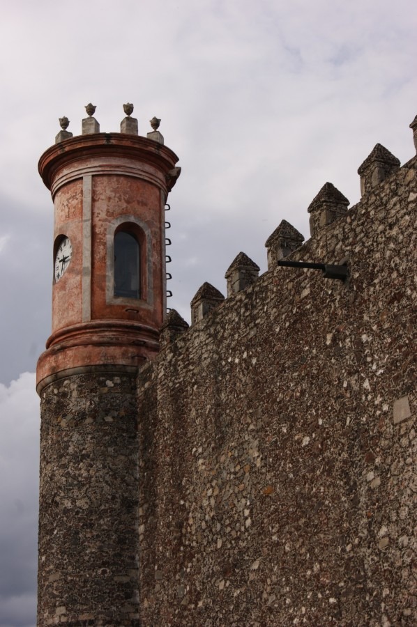 Una torre con un reloj en una pared de piedra

Descripción generada automáticamente con confianza media