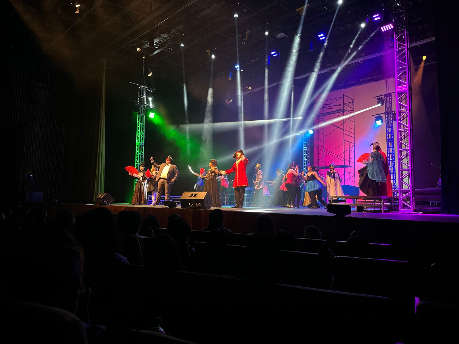 Un par de personas con instrumentos musicales en un escenario con luces

Descripción generada automáticamente con confianza baja