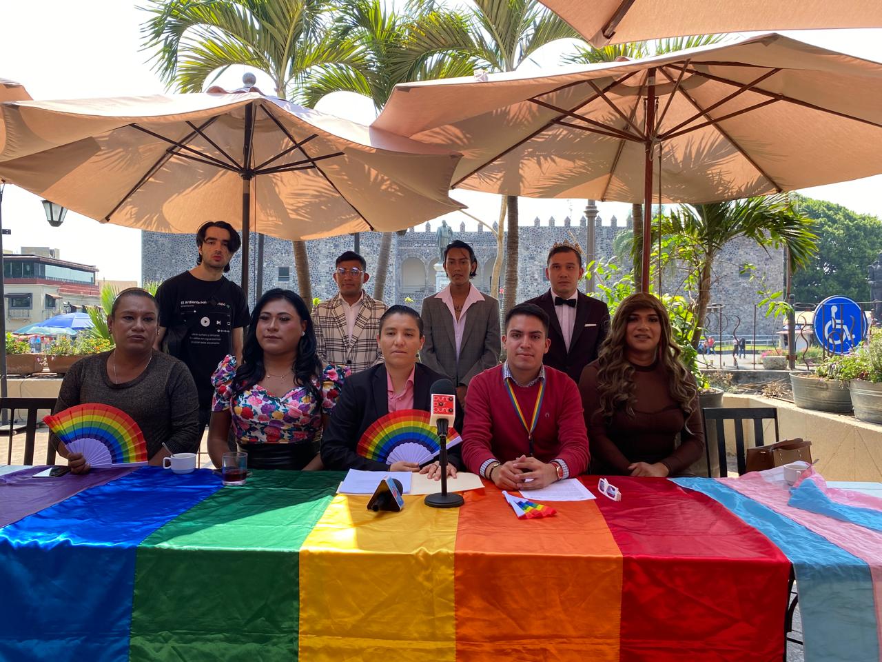 Un grupo de personas alrededor de una mesa con un paraguas de colores

Descripción generada automáticamente